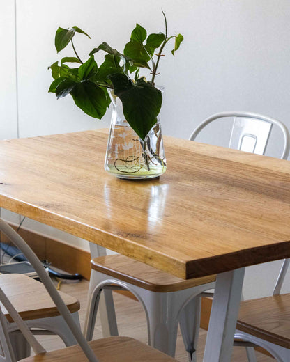 detalle cubierta mesa de comedor de madera con florero